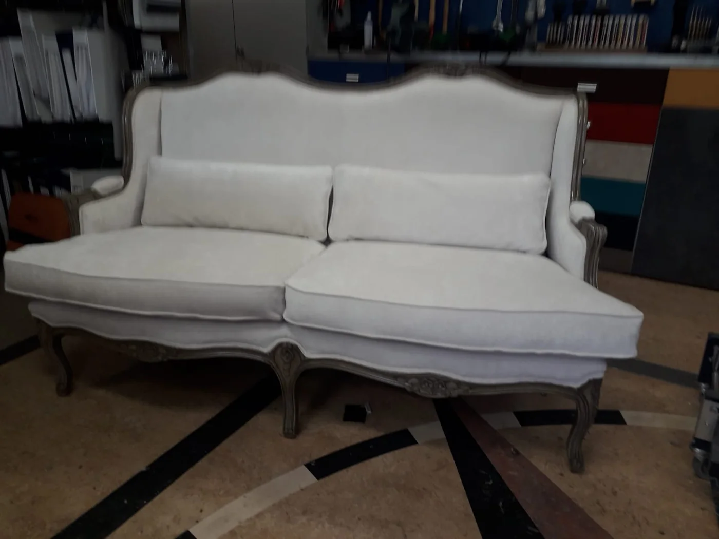 Lichte klassieke bank met een bewerkt houten frame