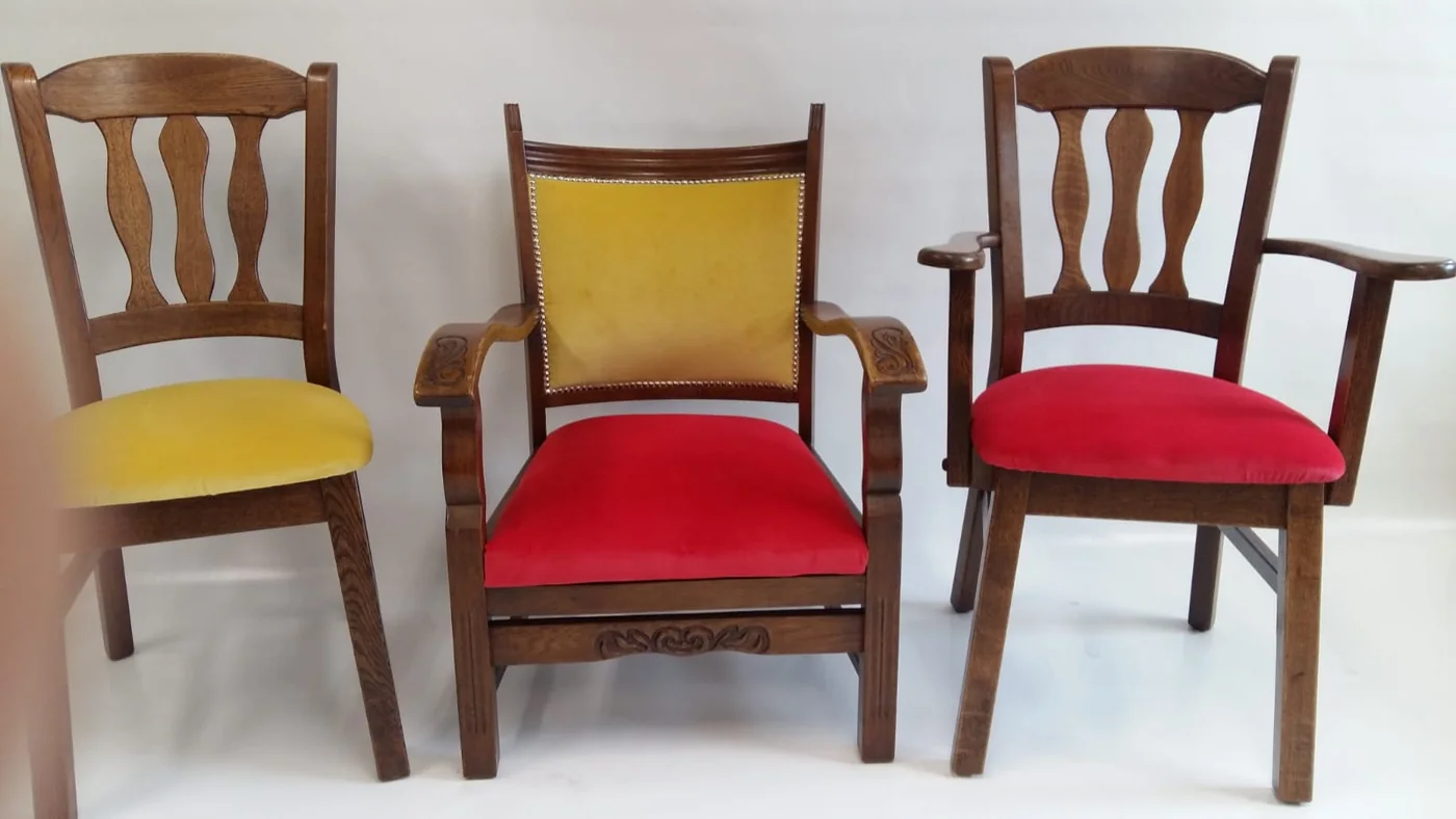 Drie houten stoelen met rode en gele bekleding