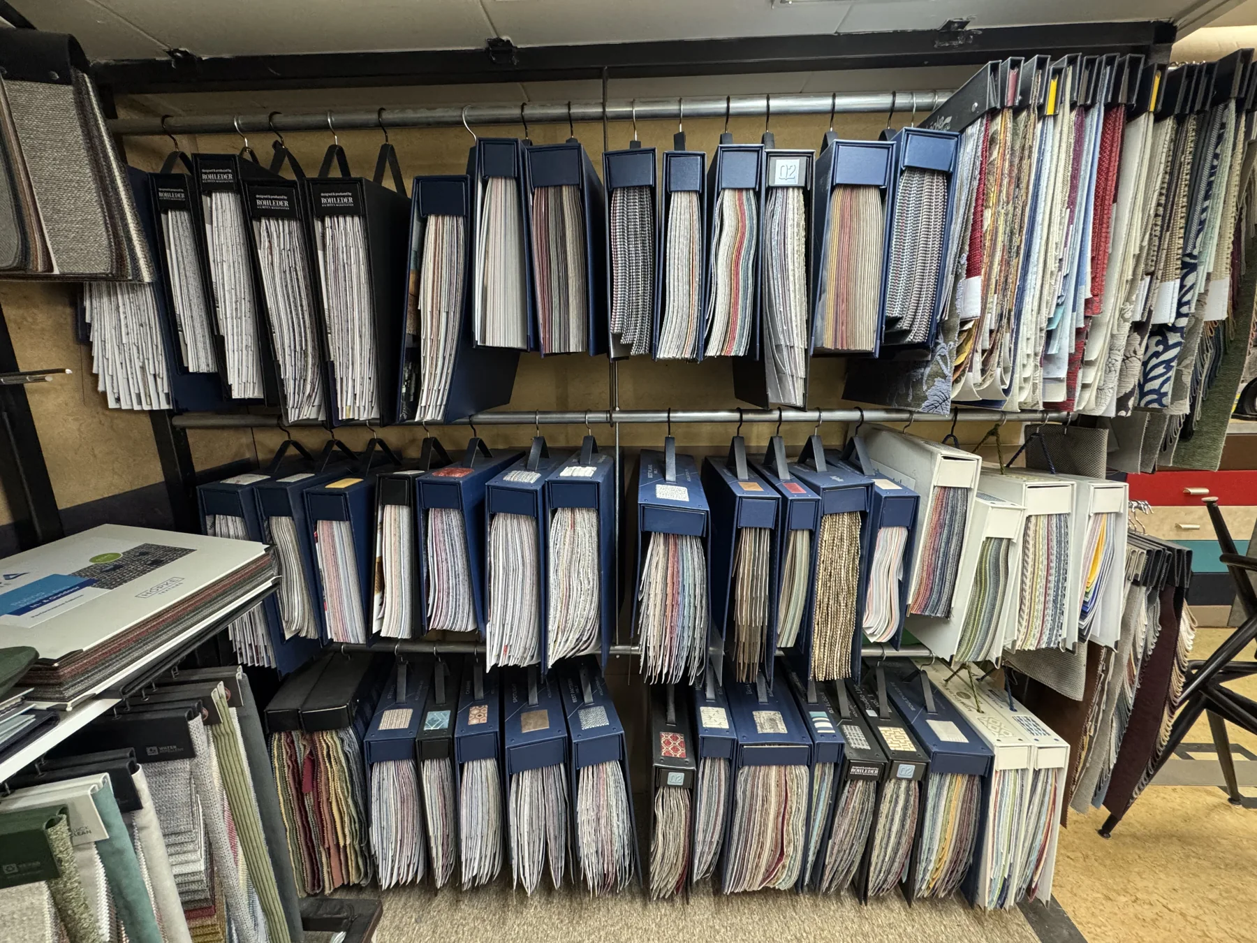 Rijen stalenboeken met stoffen in verschillende kleuren