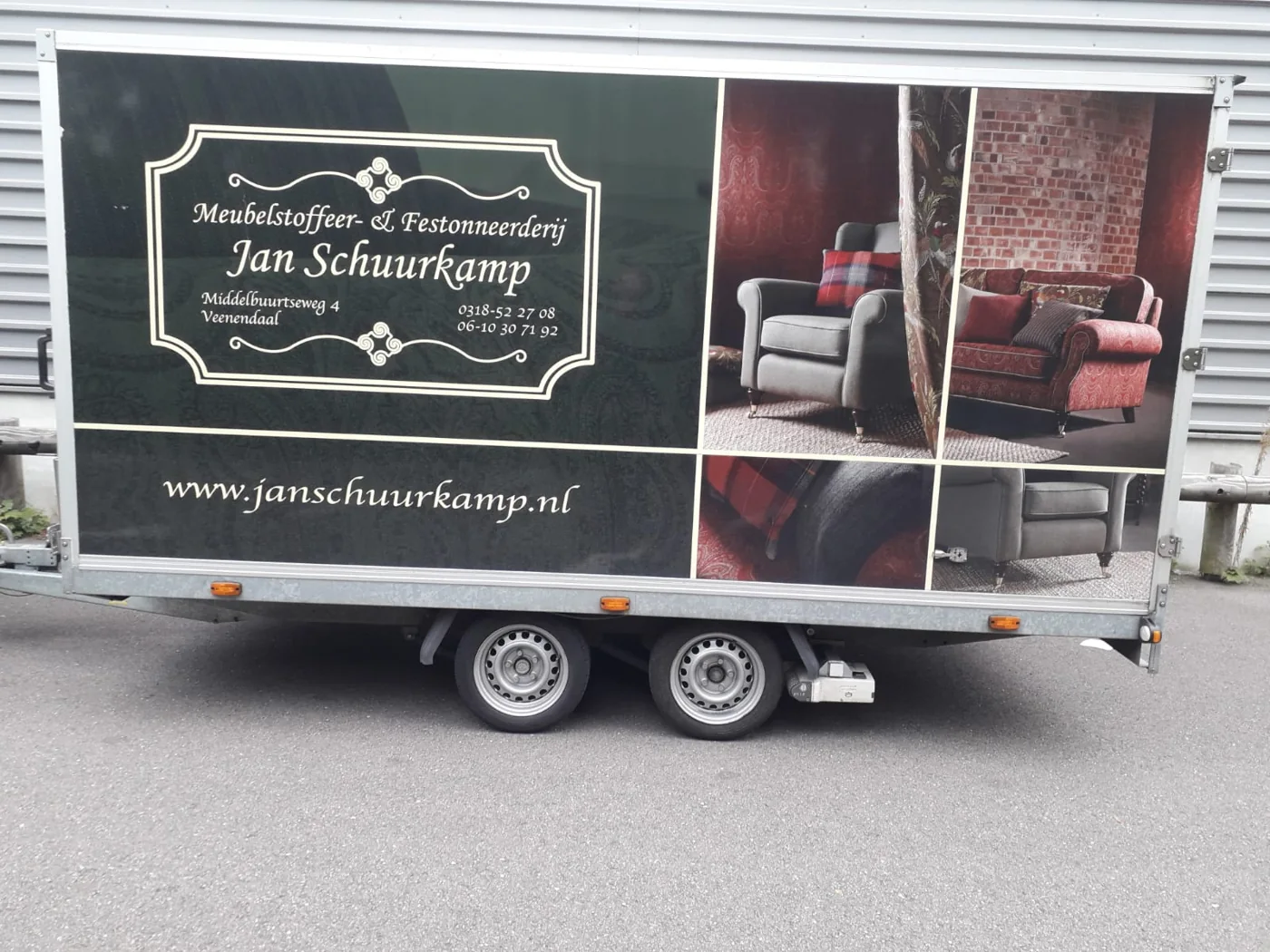 Jans aanhanger met zijn bedrijfsbelettering voor het vervoer van meubels